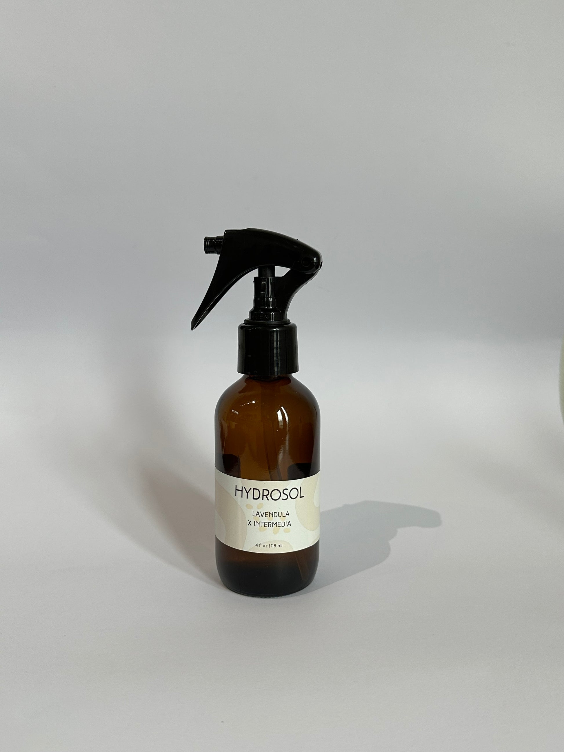 Brown 4 oz glass bottle with hydrosol with fine mist trigger spray. Lavender hydrosol, lavender water, lavender spray, linen spray, room spray