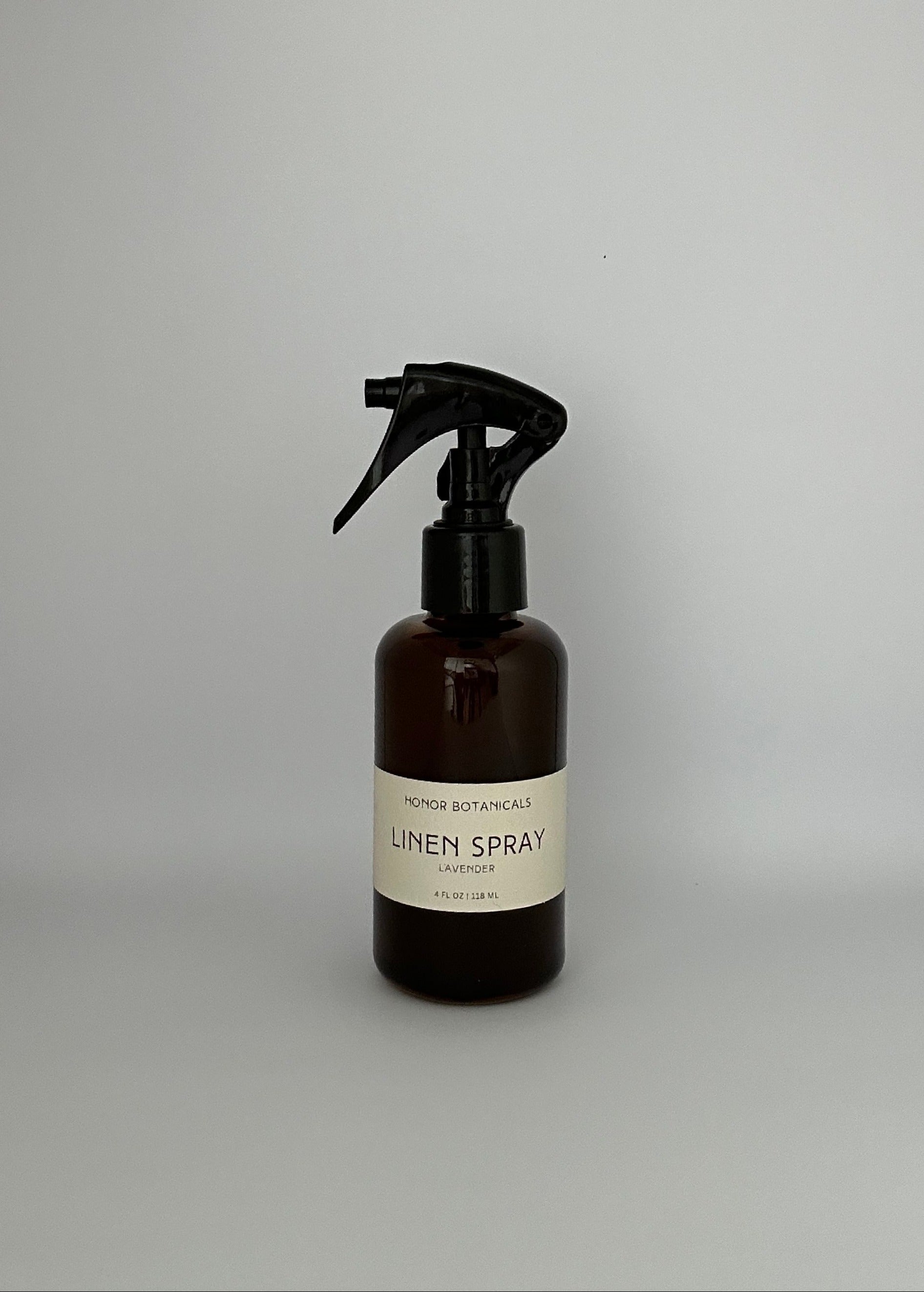 Dark brown glass lavender linen spray bottle with simple beige label.